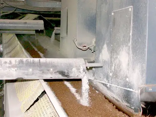 Limestone application to peat as it travels on a conveyor