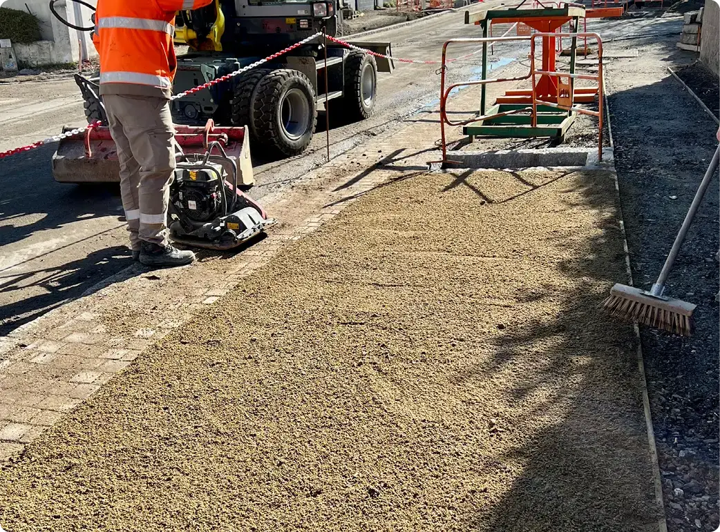 phto de la mise en oeuvre d'un revêtement perméable avec la pose des différentes couche dans un chantier urbain